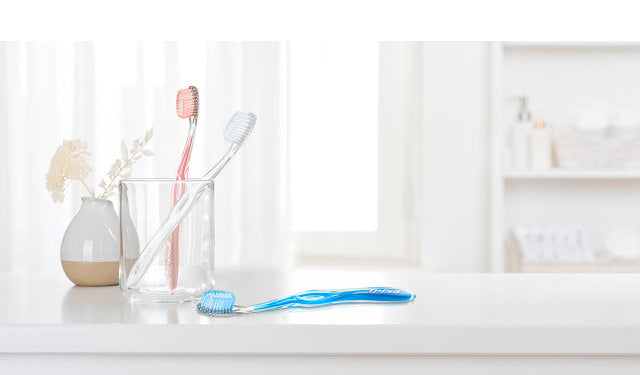 TRISA Gum Protect toothbrush positioned in a calm bathroom setting, highlighting gentle gum care.